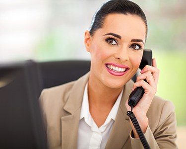 Smiling dental practice consultant answering the phone